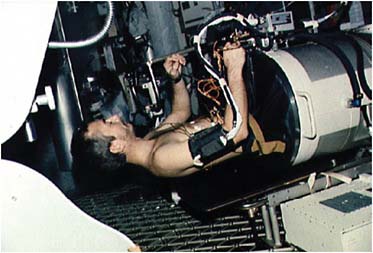 FIGURE 4.4 Skylab astronaut Owen Garriott lies in a lower body negative pressure device—a big vacuum cleaner that simulates the effects of gravity on the lower body. NASA Photo ID: SL3-108-1278. SOURCE: Courtesy of NASA.