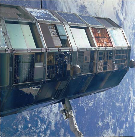 FIGURE 5.7 An overall side view of the Long Duration Exposure Facility grappled by remote manipulator system during STS-32 retrieval. SOURCE: NASA Langley Research Center. Image # EL-1994-00078.